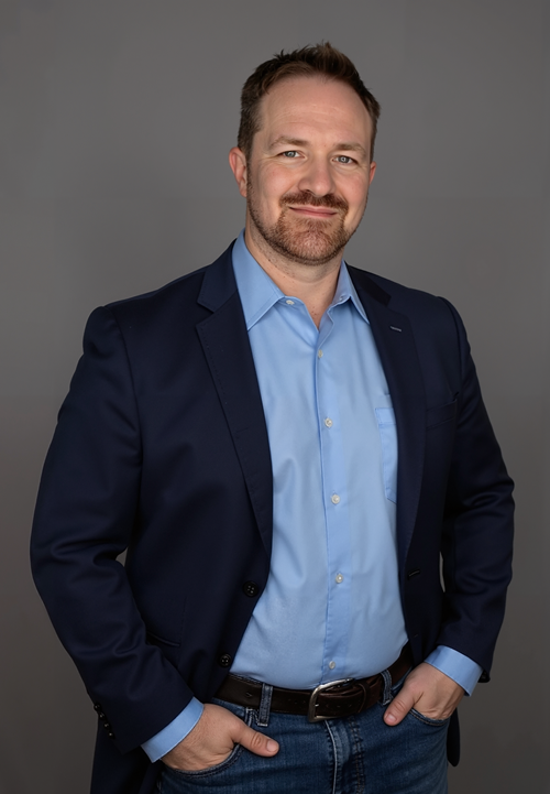 picture of mark squires standing, with AI generated background